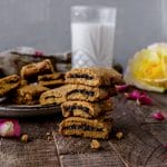 stack of homemade fig newton cookies next to a glass of milk