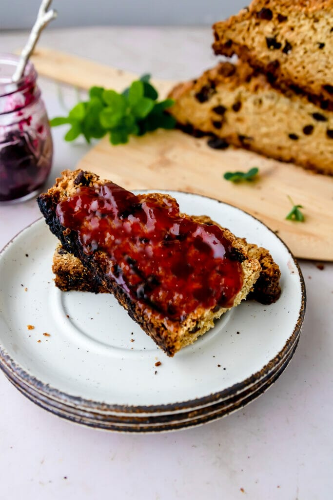 overhead shot of two slices of Irish soda bread with jam on a white plate