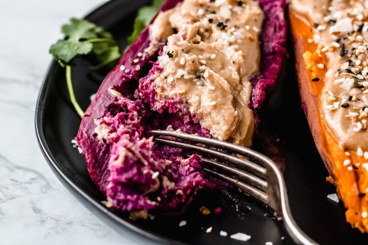 purple sweet potato on black plate with salt and tahini butter