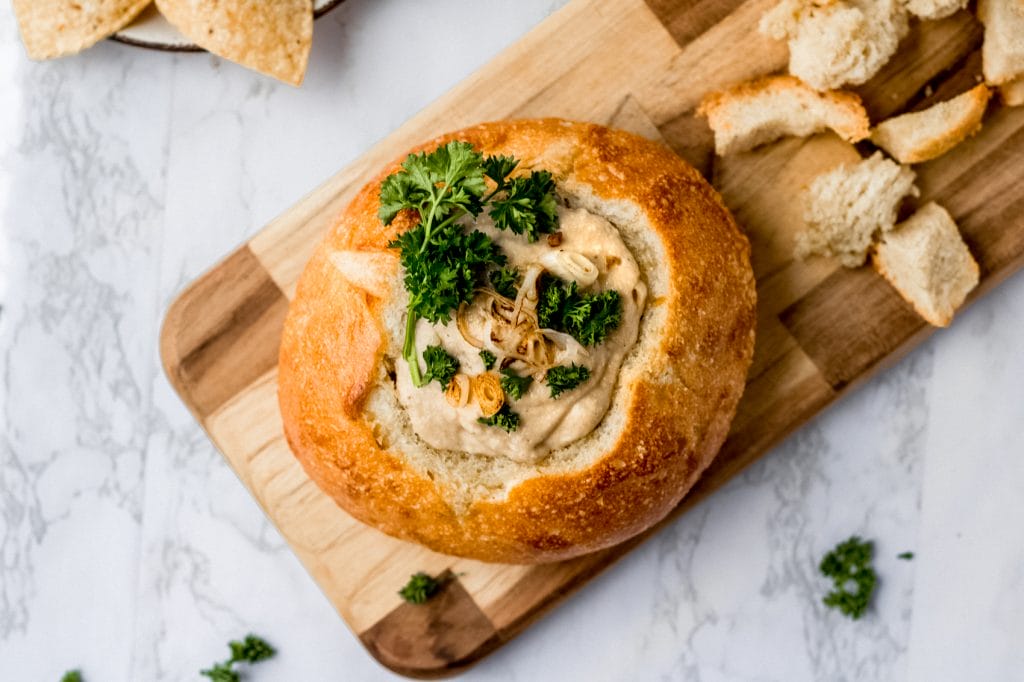 overhead shot of vegan french onion dip inside of a bread bowl