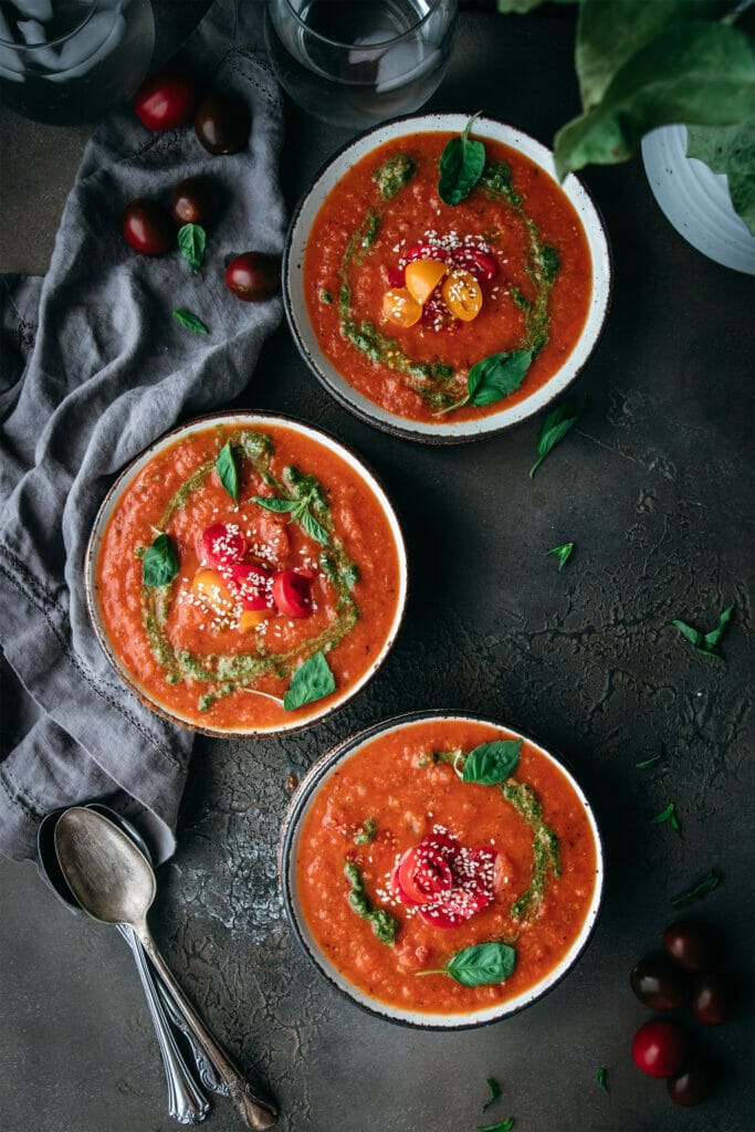 three bowls of creamy vegan tomato soup shot from overhead