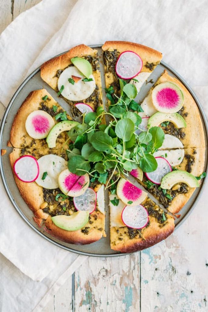 chickpea pizza crust on grey plate with pink radishes