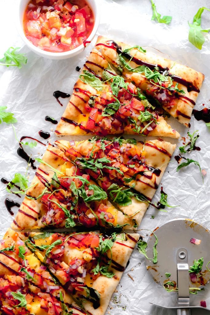 rectangular flatbread with tomatoes and balsamic on a white board 