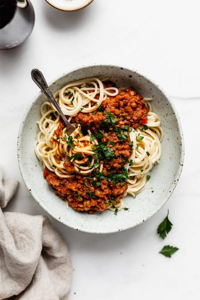 spaghetti in white bowl with red bolognese sauce