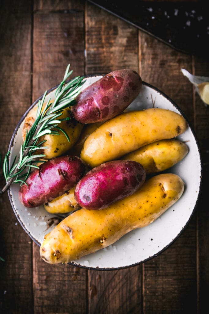 bowl of purple and white fingerling potatoes with rosemary