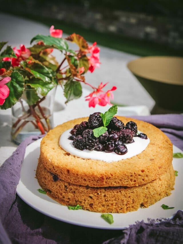 side view of a vegan olive oil cake with berries
