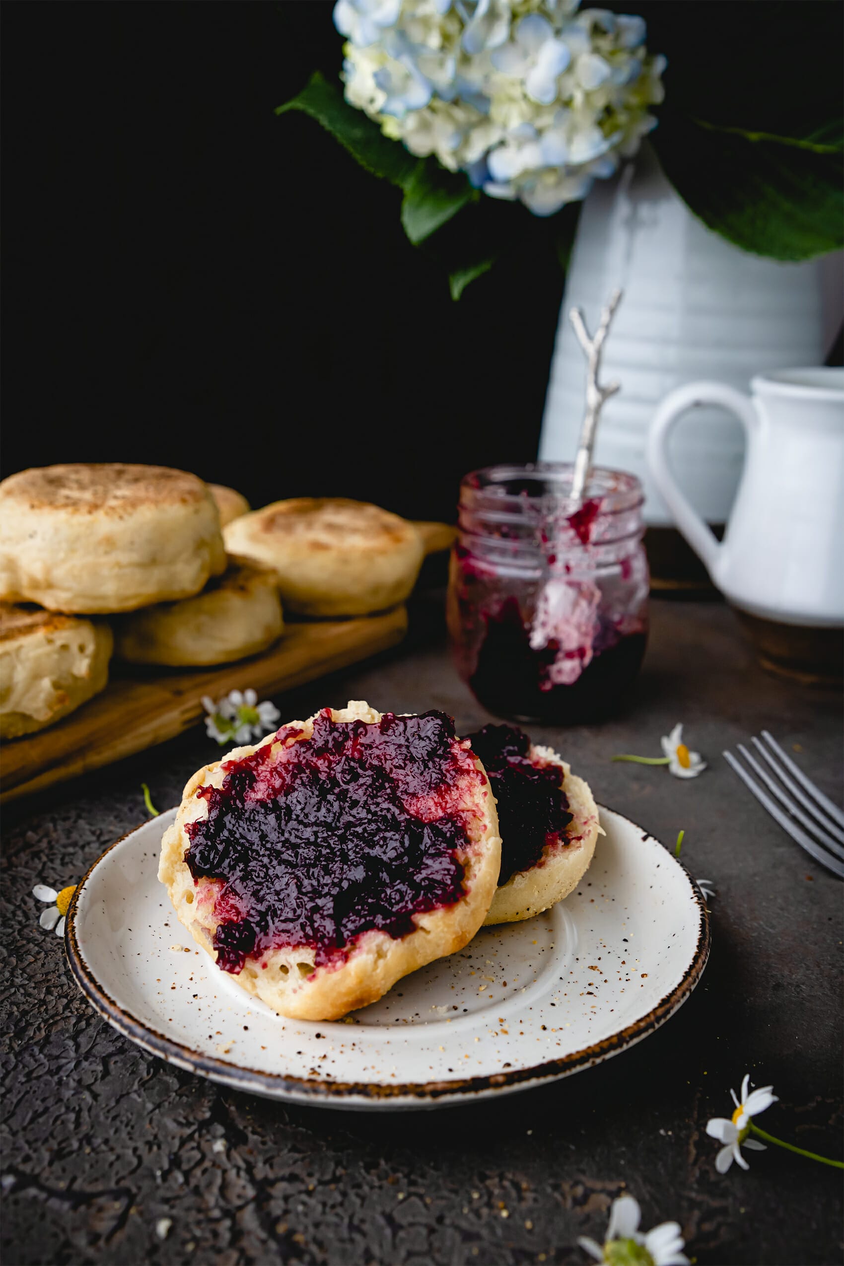 sliced open english muffin spread with blackberry jam