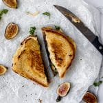 vegan honey grilled cheese sliced on a white table next to figs