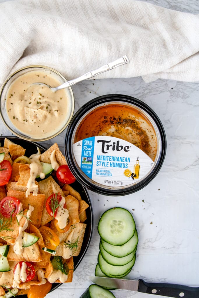 overhead shot of tribe mediterranean hummus container on a white board