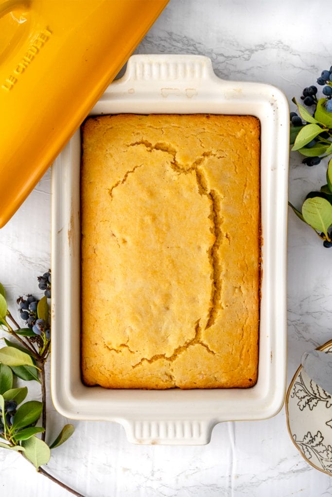 overhead shot of vegan cornbread in a le creuset ceramic yellow dish on a marble table