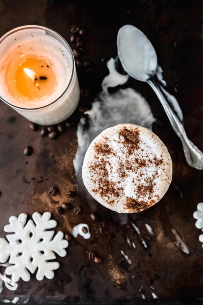 overhead shot of a vegan white Russian cocktail next to a candle