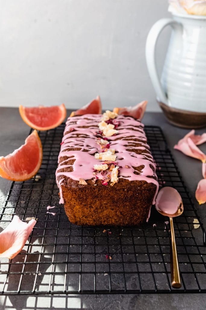 grapefruit poppyseed olive oil loaf cake on a cooling rack with a golden spoon