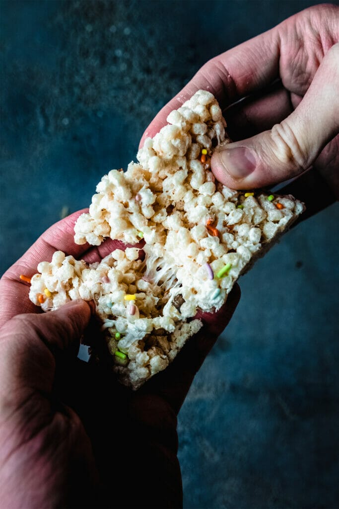 two hands pulling apart a vegan rice krispy treat