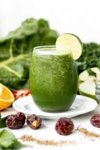 green smoothie surrounded by fresh fruit
