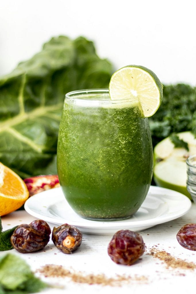 green smoothie surrounded by fresh fruit