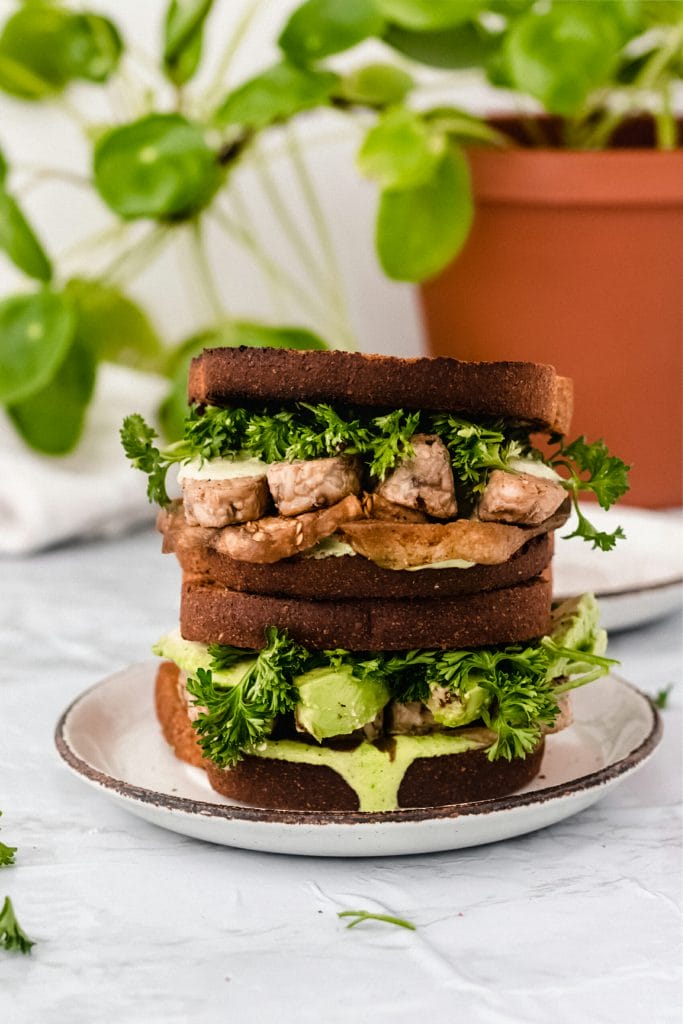 vegan tempeh blt sandwich on a white plate