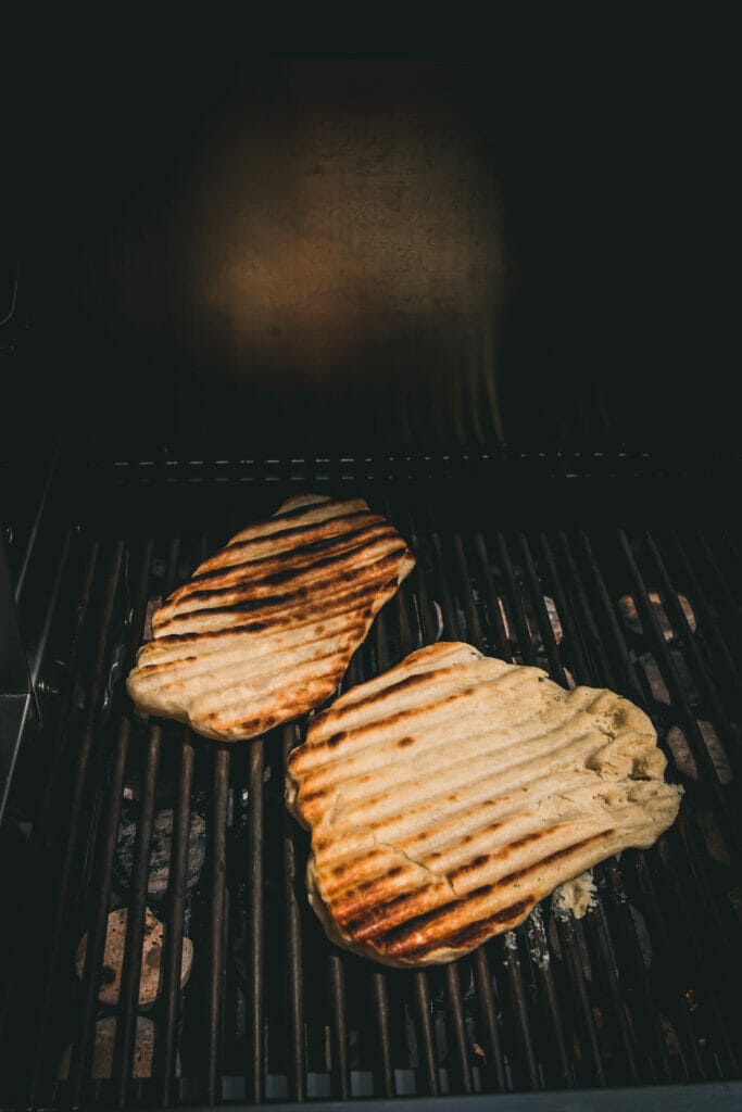 Two flatbreads being grilled