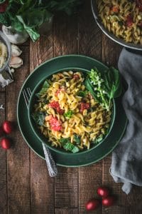 bowl of creamy sweet corn pasta with basil and tomatoes shot from overhead