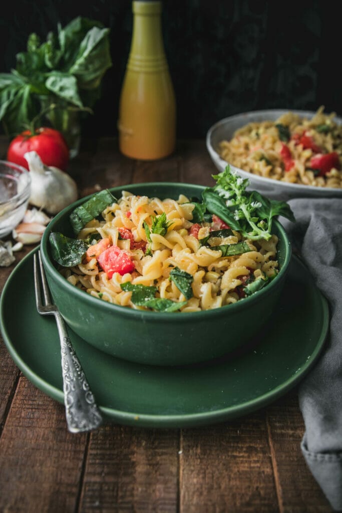 side view of creamy sweet corn pasta  in a green bowl