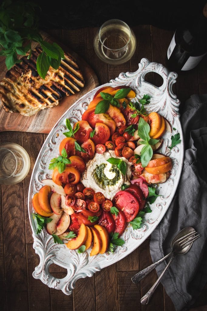 grilled flatbread next to an heirloom tomato and peach summer salad