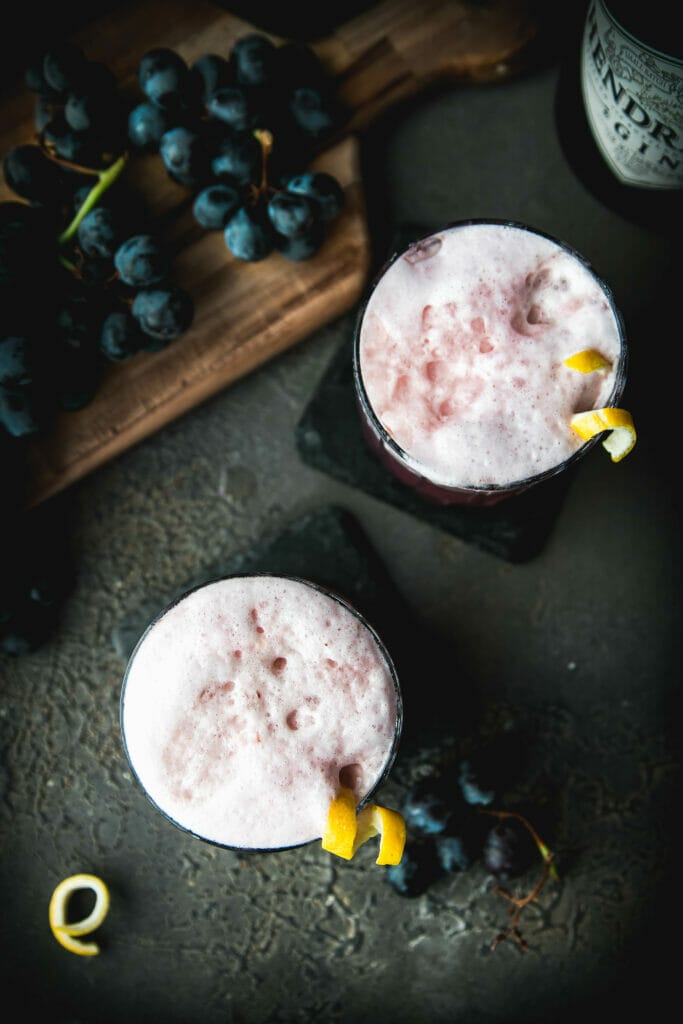 overhead shot of two foamy concord grape gin fizz cocktails