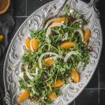 overhead shot of arugula fennel and orange salad on a white platter