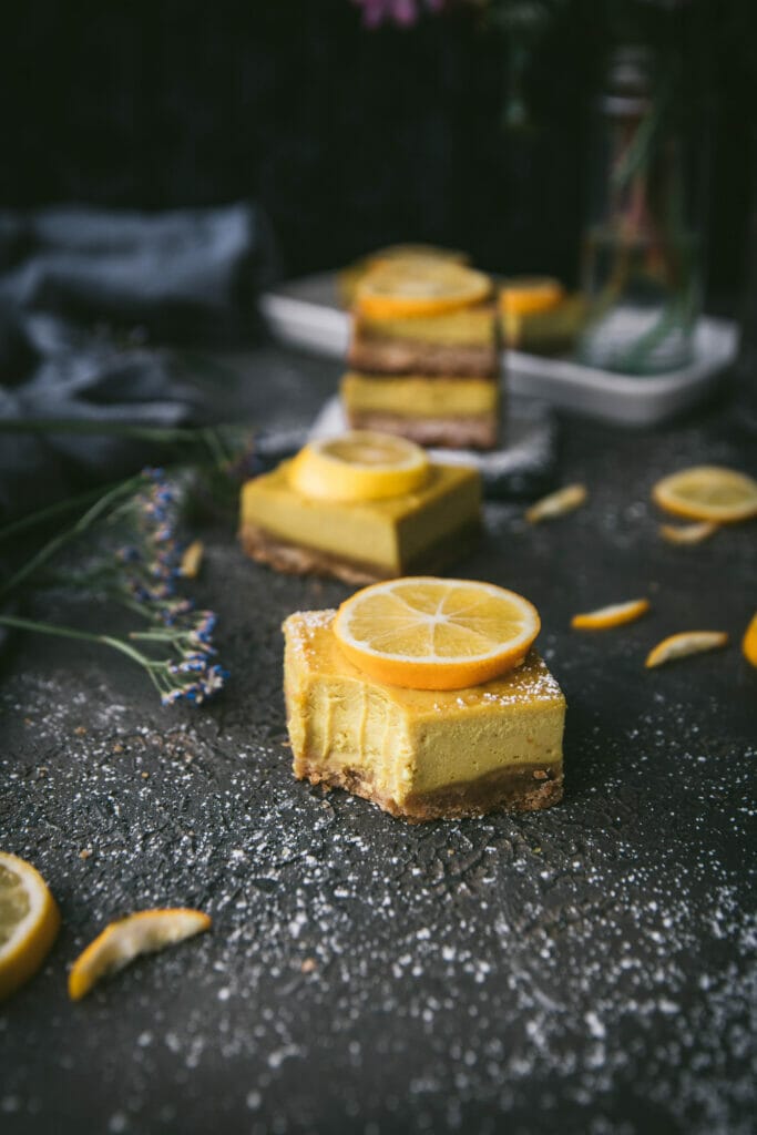 close up of vegan meyer lemon cheesecake bar with a bite taken out of it