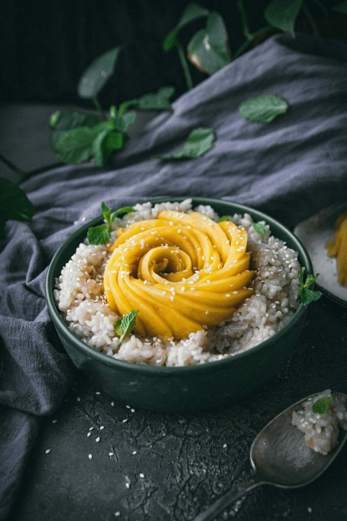 side view of overhead view of vegan mango sticky rice in a green bowl