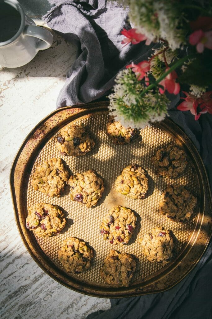 vegan gluten free granola breakfast cookies on a circular tray next to a vase of flowers
