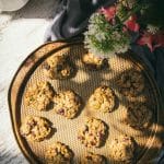 vegan gluten free granola breakfast cookies on a circular tray next to a vase of flowers