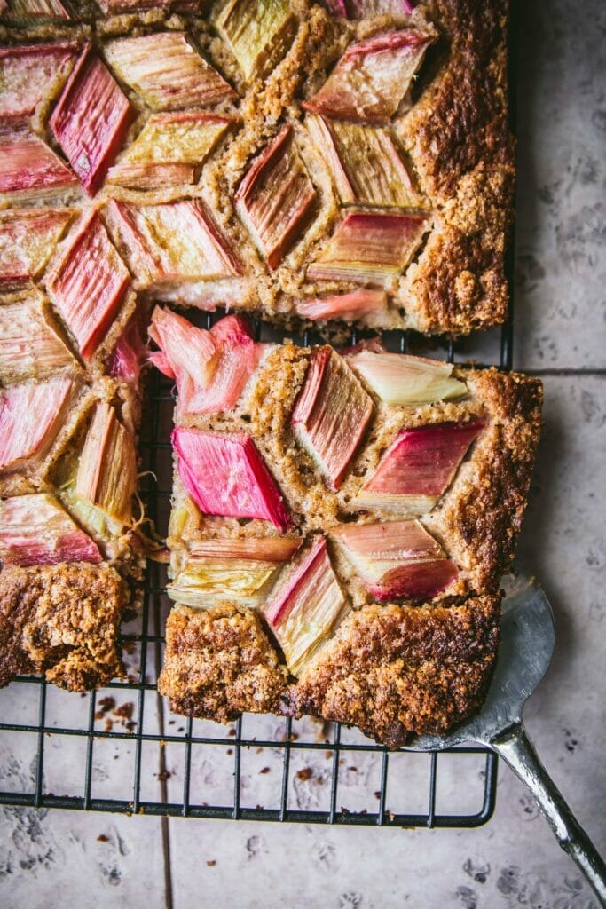 overhead shot of a tessellated rhubarb cake with one slice taken out
