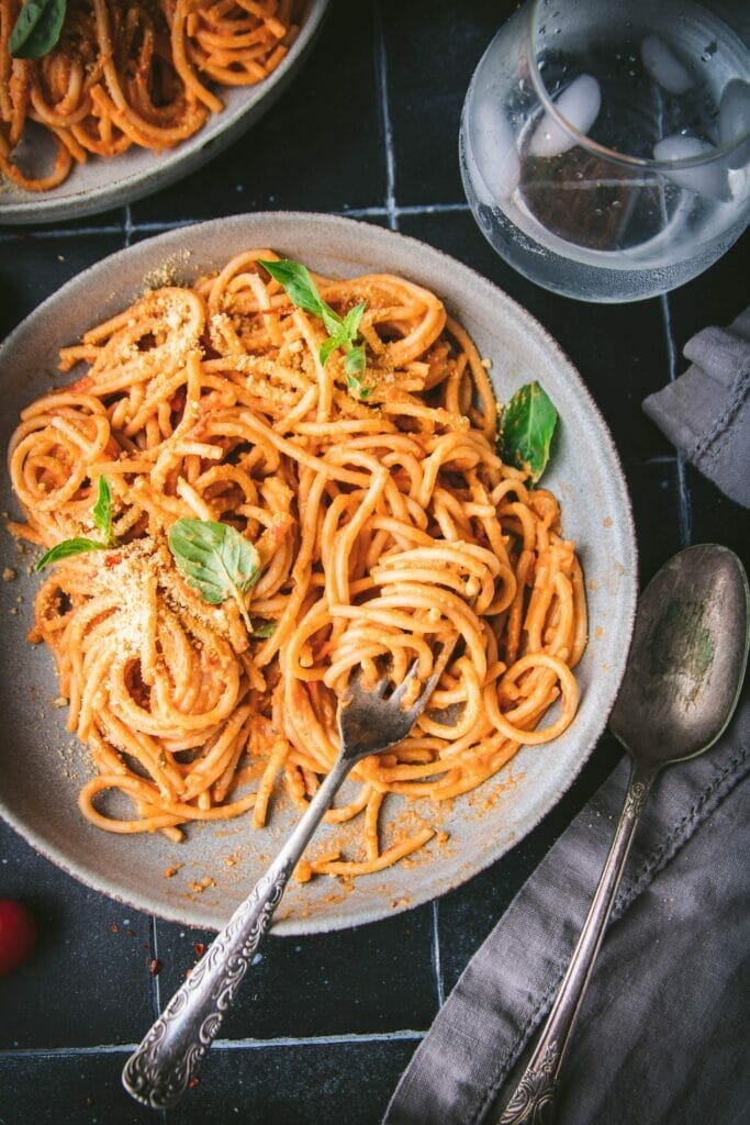close up photograph of a fork twirled around vegan cherry tomato pasta alla vodka
