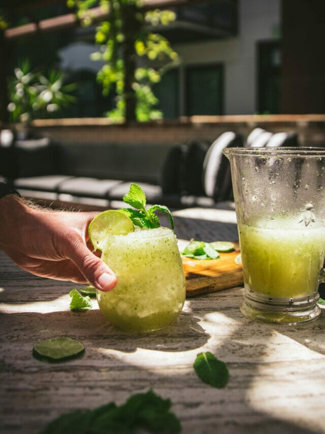hand reaching for a frozen mojito slushie next to a pitcher