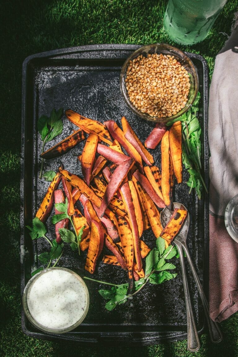 tray of grilled sweet potato salad with crispy farro and yogurt dressing in two bowls