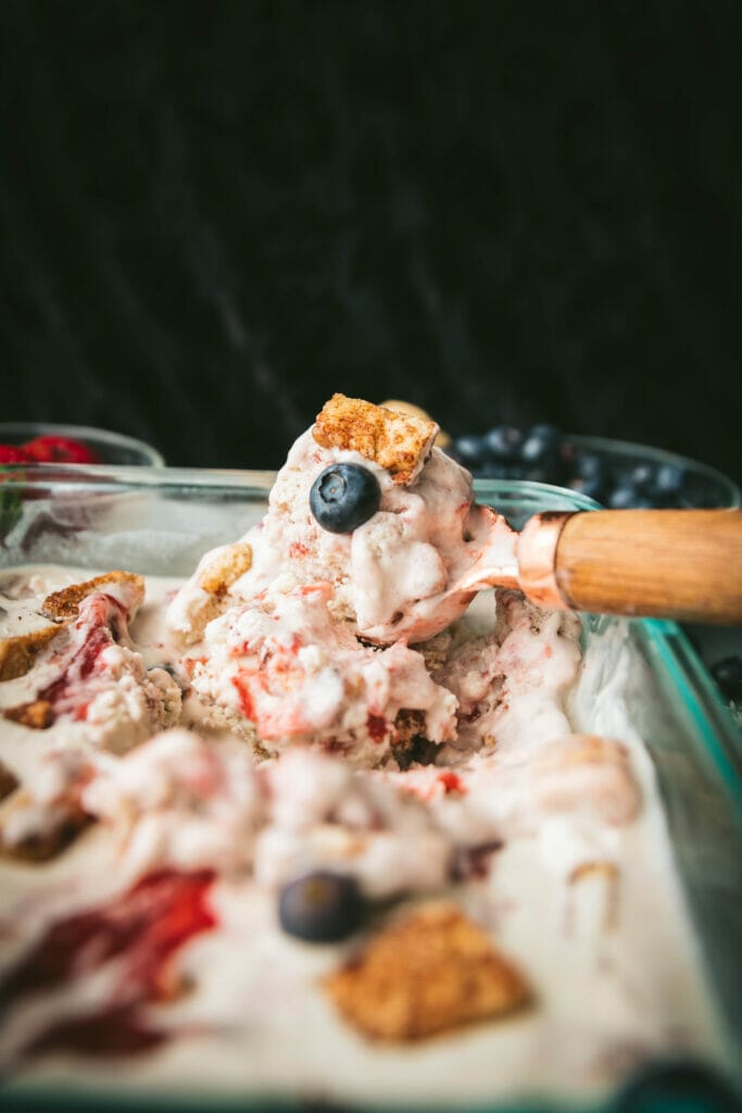 ice cream scoop with vegan no churn wild berry pie ice cream in a dish