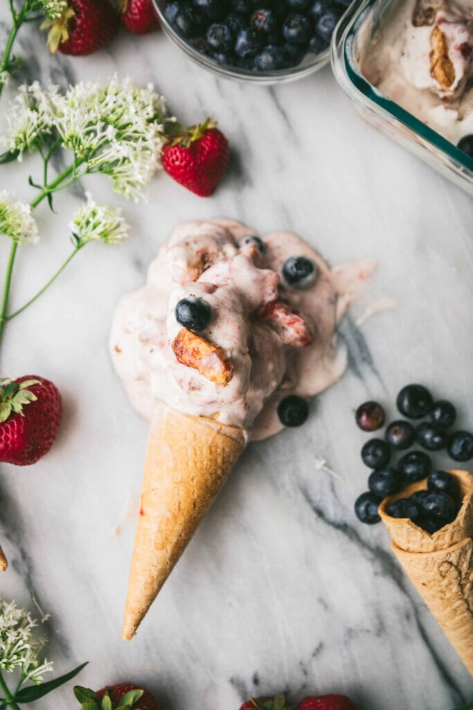 cone of vegan wild berry ice cream on a marble slab