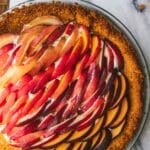 overhead shot of a peaches and cream tart on a marble table