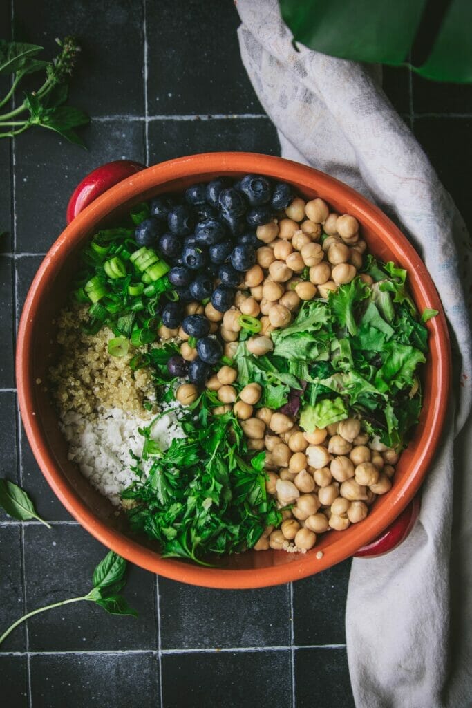 bowl with sections of chickpeas, lettuce, and herbs