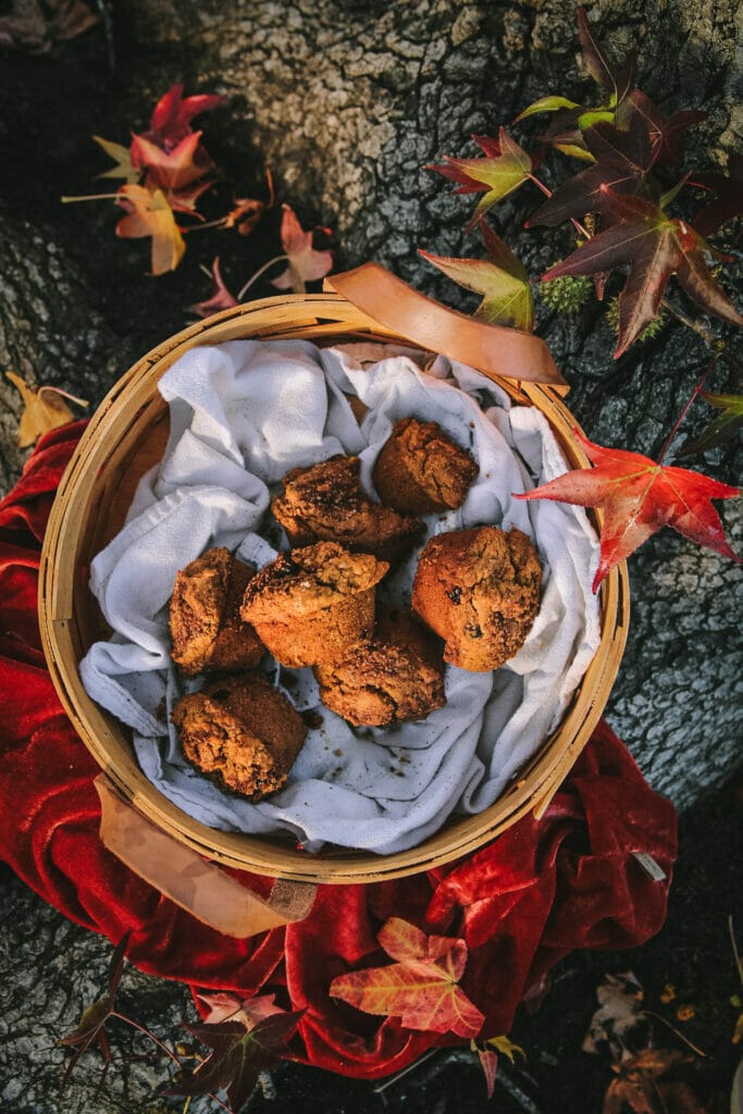 overhead shot of vegan pumpkin muffins in a basket next to a tree