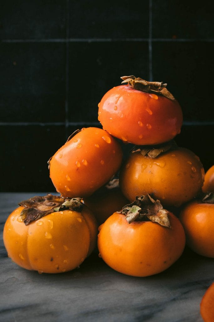 stack of persimmons on a marble tray