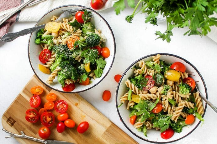 two bowls of garlic pasta with colorful vegetables