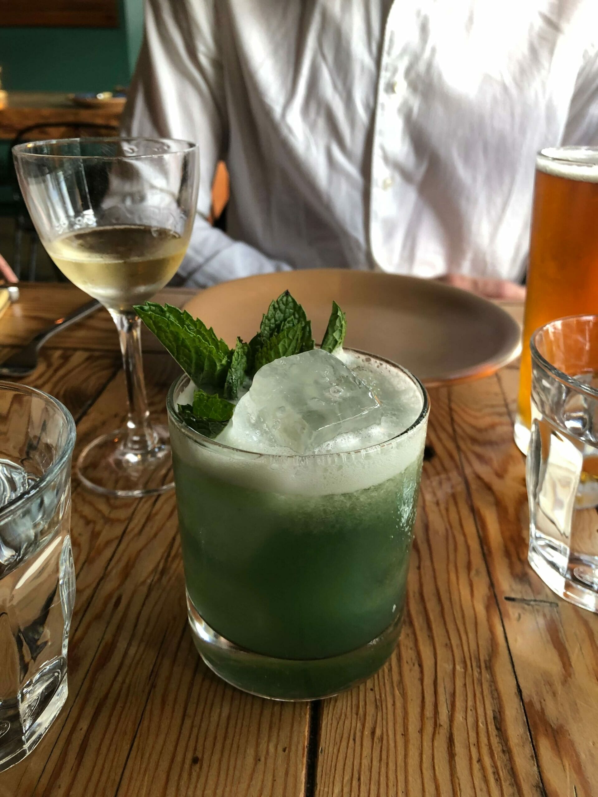 green cocktail on a wooden table from Campfire