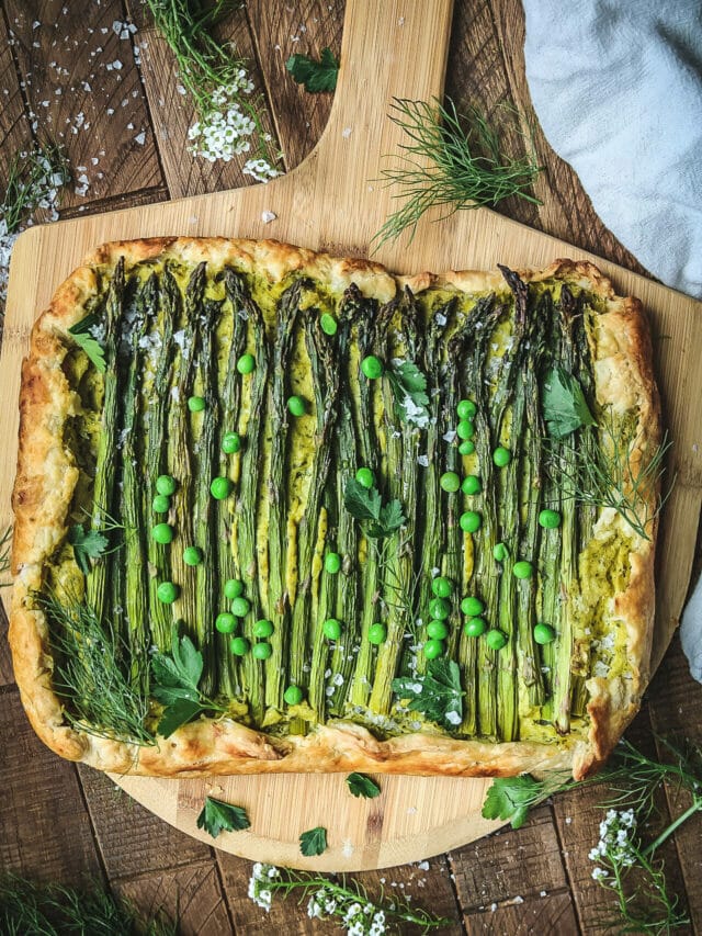 overhead shot of a vegan asparagus ricotta galette on a wooden board