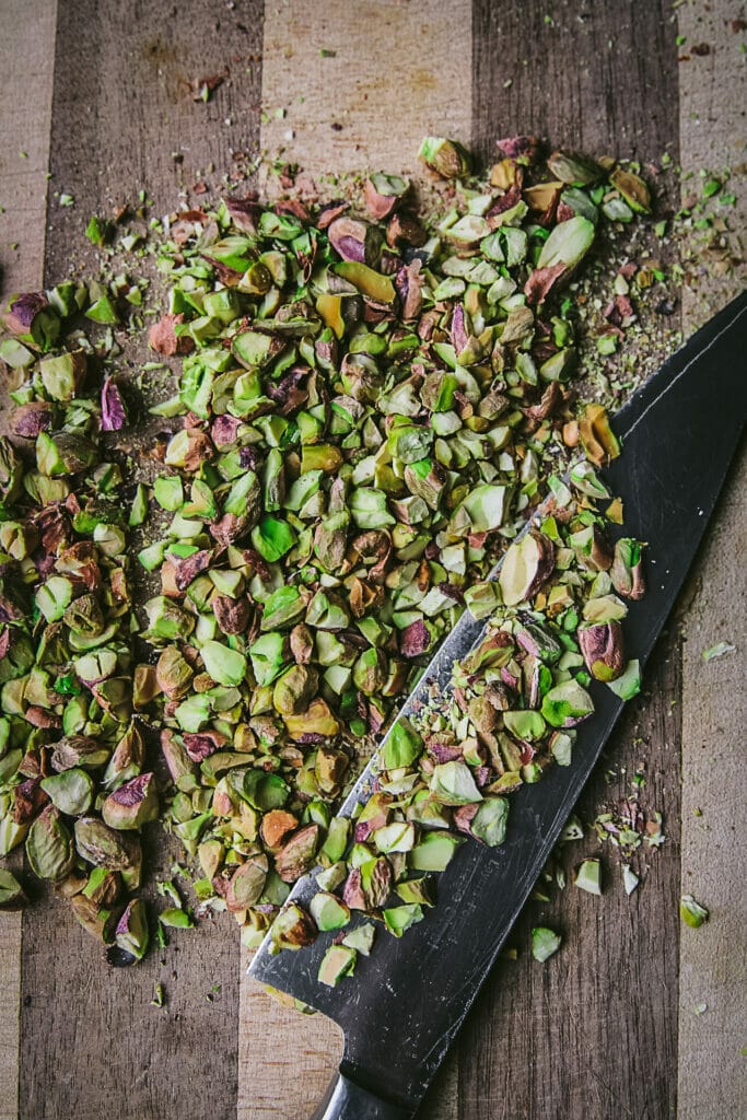 chopped and shelled pistachios on a cutting board