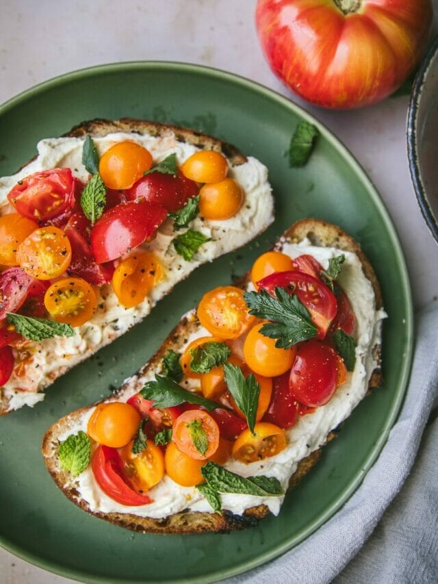 close up of whipped ricotta tomato toast on a plate