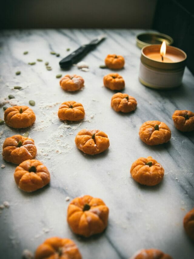 marble board with pumpkin-shaped gnocchi and a candle