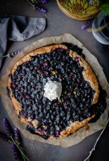 overhead shot of vegan berry galette with a scoop of ice cream in the center on a piece of parchment