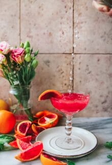 seltzer pouring into a glass of blood orange screwdriver cocktail