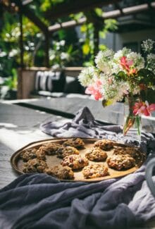 tray of breakfast cookies on a table in a garden setting next to a vase of flowers