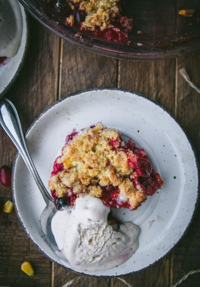scoop of cranberry cornbread crisp on a plate with ice cream